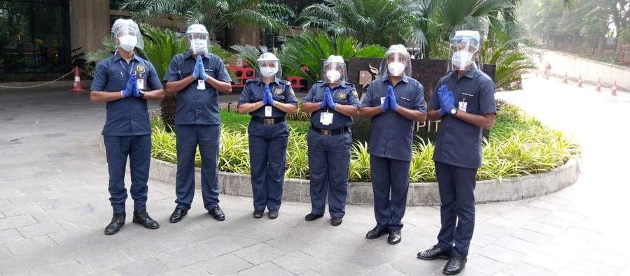 Industrial Security Force guards in full protective equipment at a hospital entrance