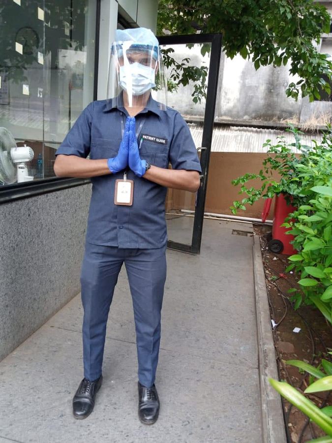 An Industrial Security Force guard in protective equipment greeting visitors